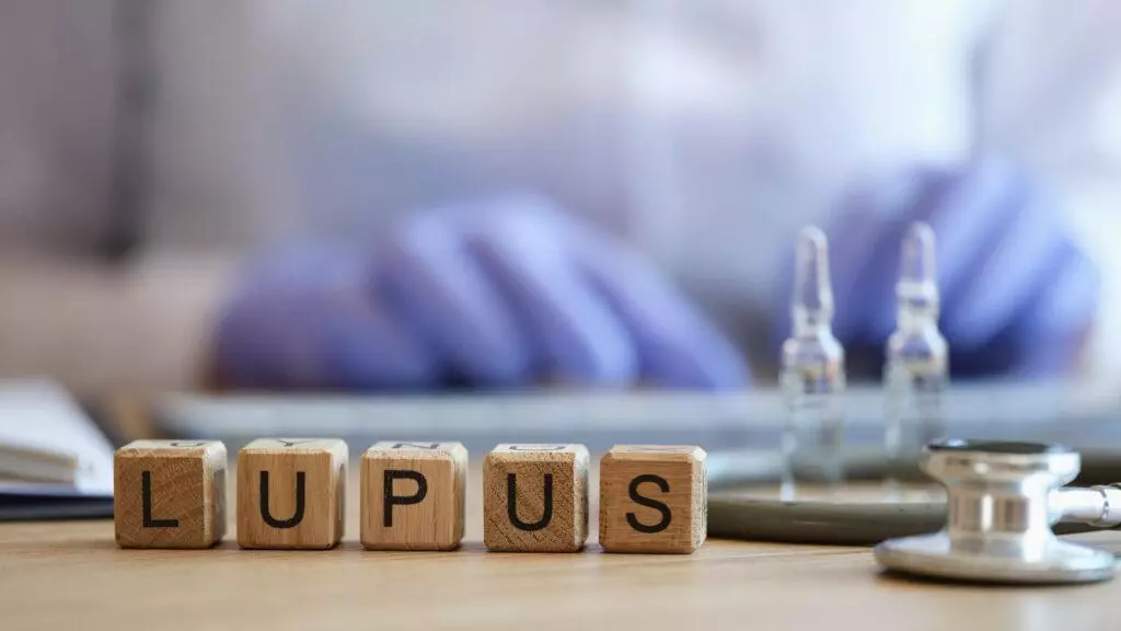 Word lupus collected of wooden cubes with a doctor in the background