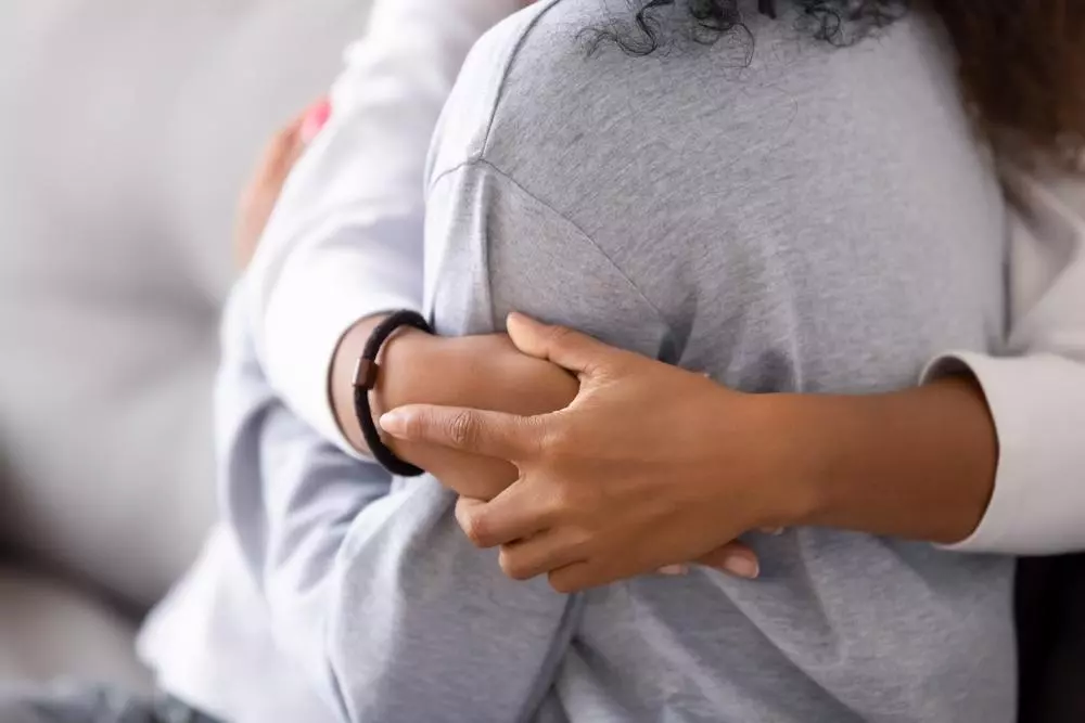 Close-up of a woman wrapping arms around another woman
