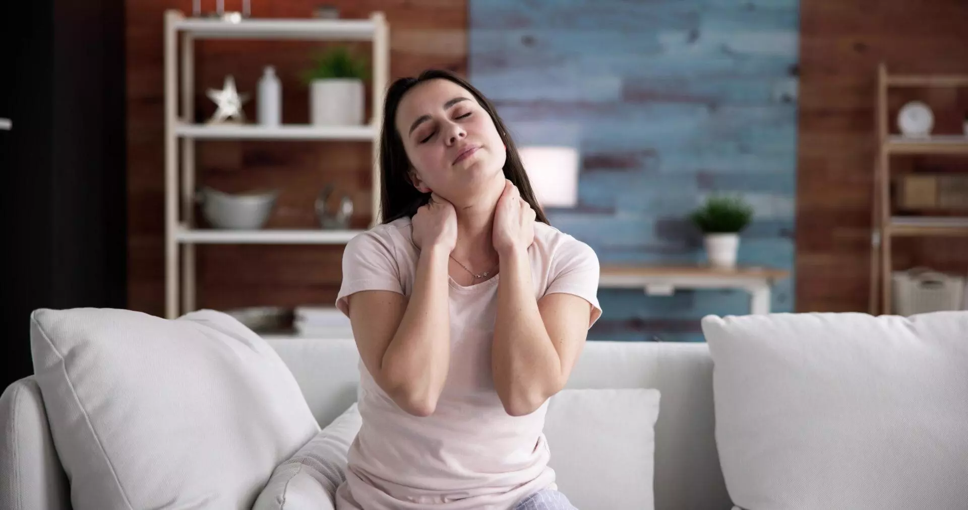 Woman suffering neck pain at home.