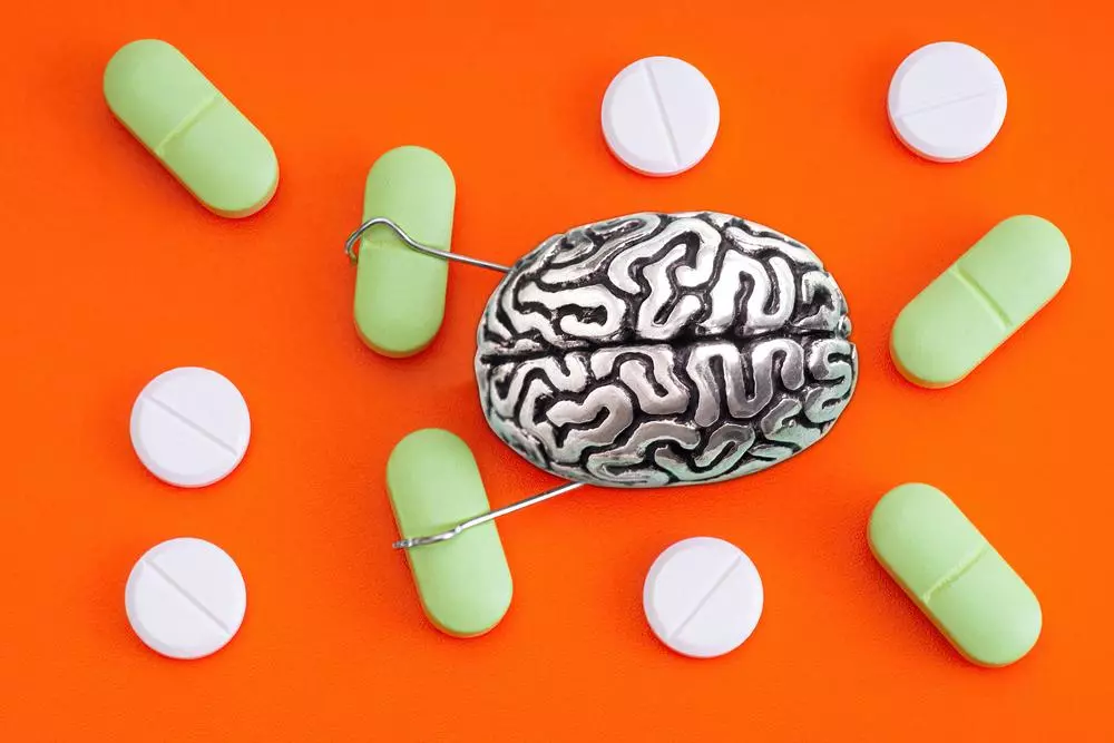 Human brain character grabbing pills with hands 