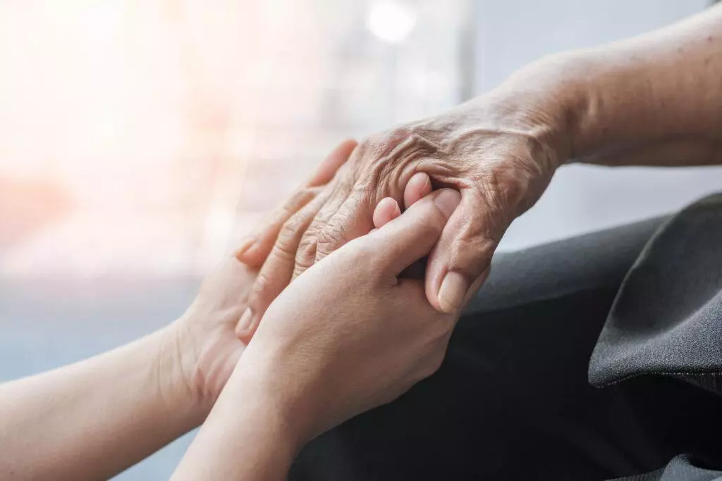 Person hand in support of nursing family caregiver care