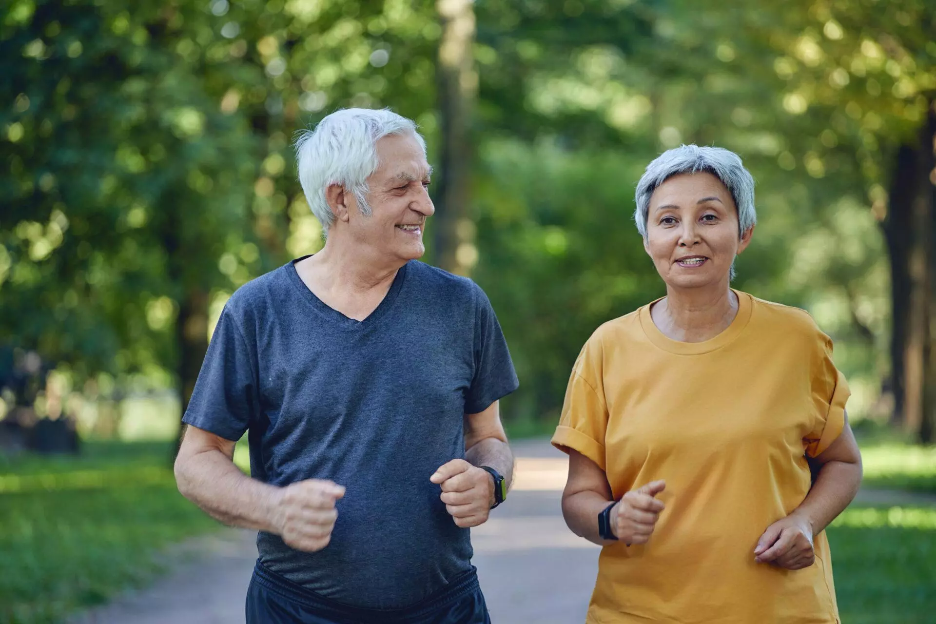 Older couple jogging in a summer park