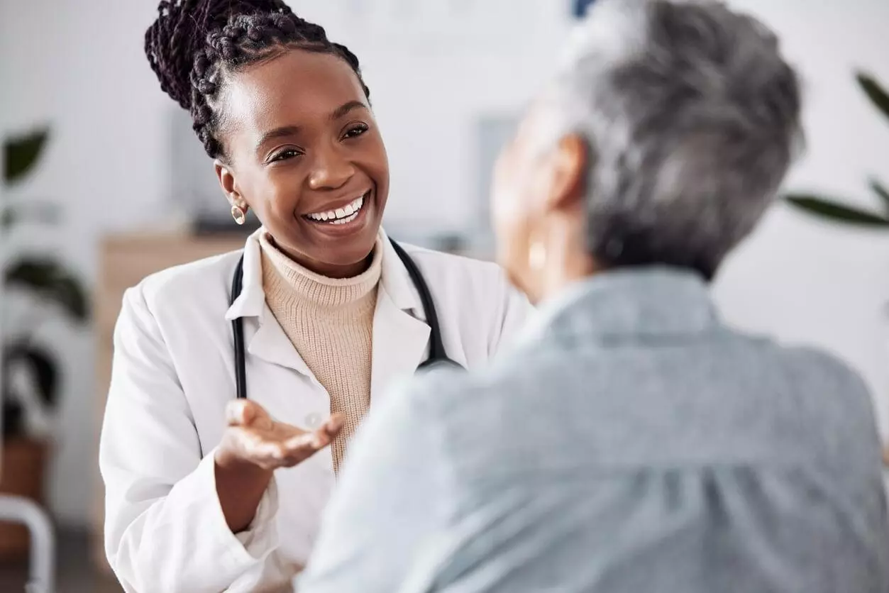A smiling doctor engaging in a friendly conversation with a patient.
